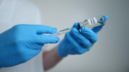 Close-up doctor hands in gloves filling syringe with Covid-19 vaccine in vaccination center. Unrecognizable Caucasian man preparing coronavirus vaccine jab in hospital medical clinic. Pandemic concept