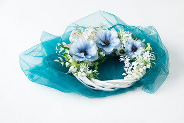 ターコイズブルーのチュールと青いラナンキュラスと白い花と白い葉のリース