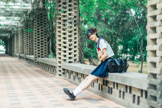 A girl in a Japanese school uniform at an amusement park