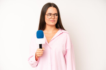 hispanic pretty woma covering mouth with hands with a shocked. journalist with a microphone