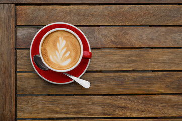 Cup of aromatic coffee on wooden table, top view. Space for text
