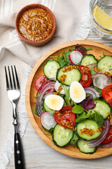 Tasty salad with vegetables and quail eggs on wooden table, flat lay