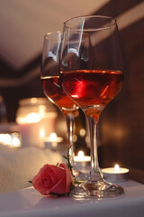 Glasses of wine and rose on tub in bathroom. Romantic atmosphere