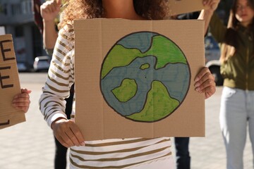 African American woman with poster protesting against climate change outdoors, closeup