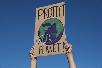 Man with poster protesting against climate change outdoors, closeup
