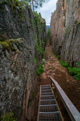 Slattdalsskrevan Canyon in Skuleskogen National Park, Sweden. Narrow crevasse in solid rock on a cloudy summer day. Hiking along the High Coast Trail in Sweden. Hohe Kustenleden trail.