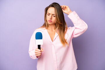 pretty caucasian woman smiling happily and daydreaming or doubting. journalist and microphone...