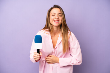 pretty caucasian woman laughing out loud at some hilarious joke. journalist and microphone concept