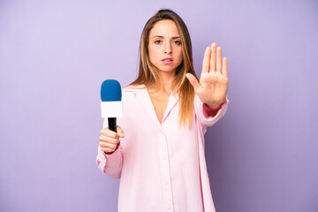 pretty caucasian woman looking serious showing open palm making stop gesture. journalist and...