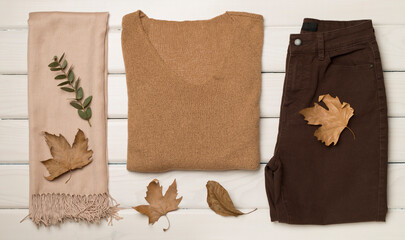 Flat lay of women's stylish autumn outfit on wooden background