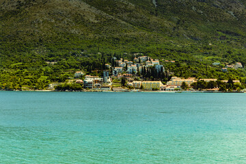View from the bay to the town of Cavtat in Croatia, June, daytime, the slope of the mountain covered with vegetation.
