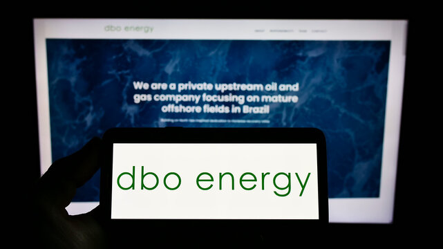 Stuttgart, Germany - 01-08-2022: Person holding mobile phone with logo of Brazilian oil and gas company DBO Energy SA on screen in front of web page. Focus on phone display.