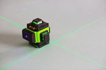 Construction and finishing works indoors. Laser construction level with green beams on the wall. Apartment renovation and construction work.