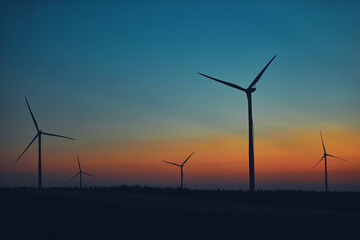 Windmill farm park in silhouettes with colorful sky.