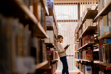 Girl leaning on the bookshelves