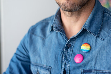 plate, multicolored flag badge that represents LGTBIQ pride on the chest of a person, man. closeup...