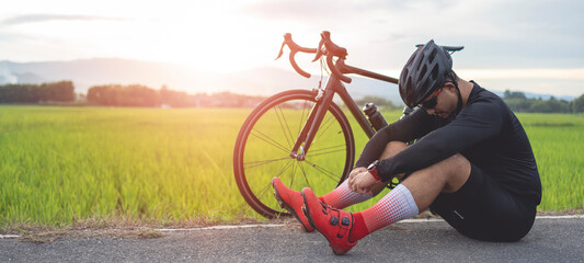 Male cyclist sitting exhausted There are race bikes on the side. Hard training.
