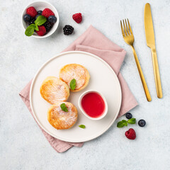 Cottage cheese fritters or Syrniki served with sauce and berries, top view. Ukrainian, Russian food