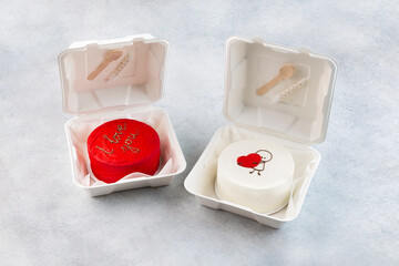 Plastic lunch box with tasty bento cake and gifts for Valentine's Day on white background