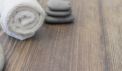 Fototapeta na wymiar White towel with spa stones on wood