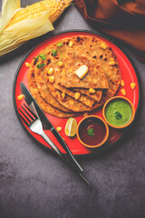 Sweet corn stuffed paratha or parotha served in a plate, Indian flatbread recipe made filling makai