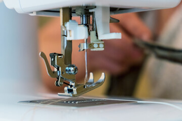 Sewing machine parts close-up - foot and needle. Selective focus