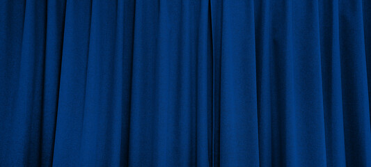 close up view of dark blue curtain in thin and thick vertical folds made of black out sackcloth...