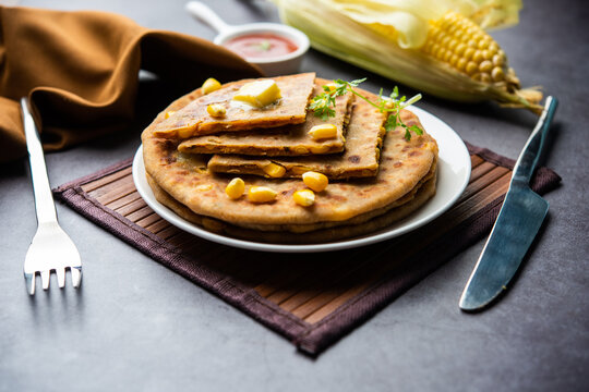 Sweet corn stuffed paratha or parotha served in a plate, Indian flatbread recipe made filling makai