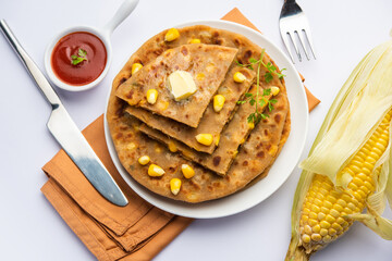 Sweet corn stuffed paratha or parotha served in a plate, Indian flatbread recipe made filling makai