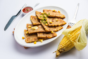 Sweet corn stuffed paratha or parotha served in a plate, Indian flatbread recipe made filling makai