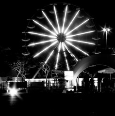 Roda gigante iluminada com vários tons e cores a noite no Parque do Ibirapuera, São Paulo, Brasil.
