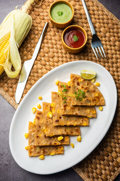 Sweet corn stuffed paratha or parotha served in a plate, Indian flatbread recipe made filling makai
