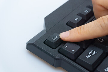 A woman's finger holding a computer keyboard
