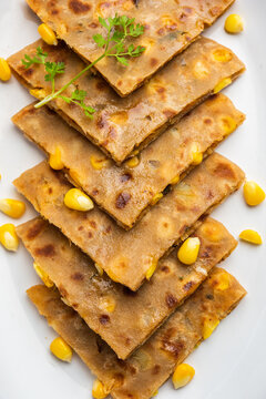 Sweet corn stuffed paratha or parotha served in a plate, Indian flatbread recipe made filling makai