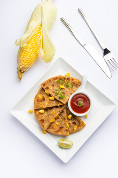 Sweet corn stuffed paratha or parotha served in a plate, Indian flatbread recipe made filling makai