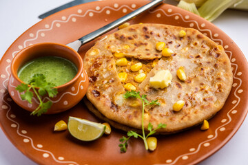 Sweet corn stuffed paratha or parotha served in a plate, Indian flatbread recipe made filling makai