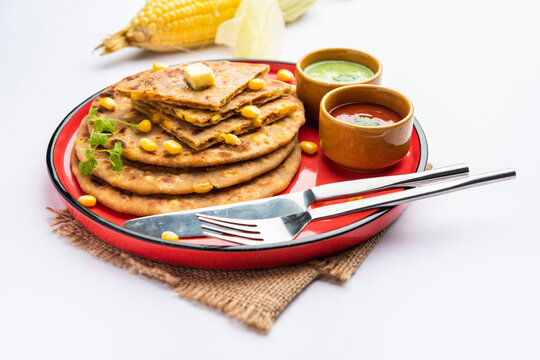 Sweet corn stuffed paratha or parotha served in a plate, Indian flatbread recipe made filling makai