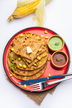 Sweet corn stuffed paratha or parotha served in a plate, Indian flatbread recipe made filling makai