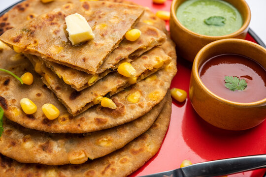 Sweet corn stuffed paratha or parotha served in a plate, Indian flatbread recipe made filling makai