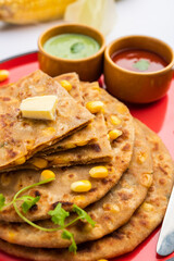 Sweet corn stuffed paratha or parotha served in a plate, Indian flatbread recipe made filling makai
