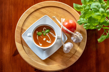 Zupa pomidorowa z bazylią na drewnianej podstawce tapeta tło - obrazy, fototapety, plakaty