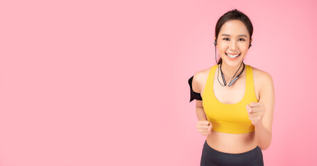 Sporty young woman running Happy Healthy girl love exercise for diet and good health Pretty lady look at camera with smile face stand over pink background copy space Health care and Sport concept