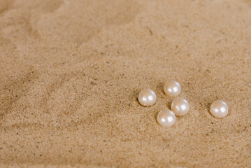 Fototapeta na wymiar white round pearls on the sand
