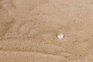 white round pearls on the sand
