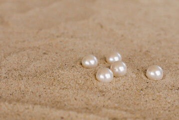 white round pearls on the sand