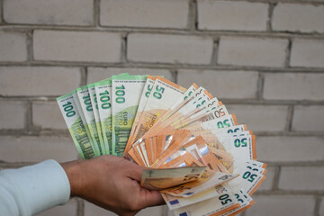 Euro banknotes in man's hand, green background