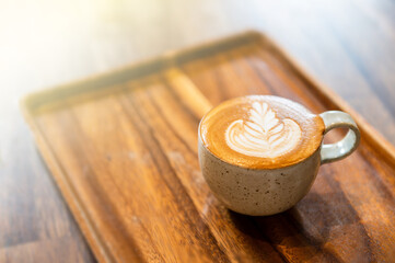 Coffee in ceramic cup on wooden table in cafe