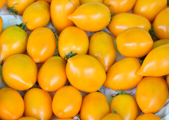 Ripe yellow tomatoes of the new harvest are sold at the bazaar 