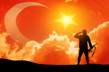 Silhouette of soldier on a background of Turkey flag and the sunset or the sunrise. Concept of crisis of war and conflicts between nations. Greeting card for Turkish Armed Forces Day, Victory Day.