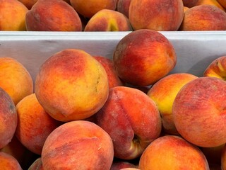 Fresh peaches in a cardboard box for sale at a farmer's market